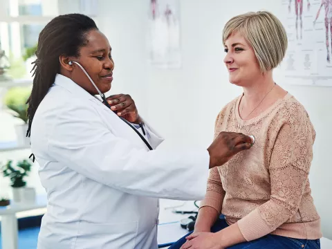 An adult woman gets her heart checked at the doctor office