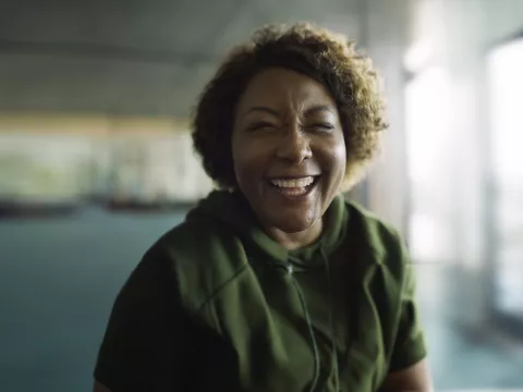 A smiling woman in a large empty room