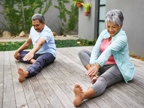 A couple doing leg stretches outdoors