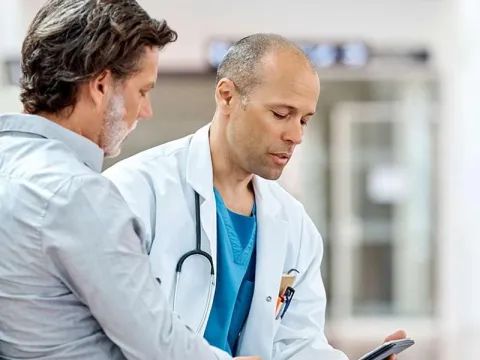 Male doctor talking to man with beard