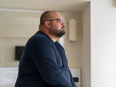 A man sitting at home looking onward.