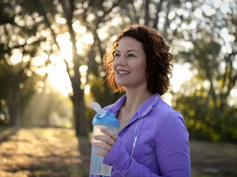 A woman outdoors taking a break from a run