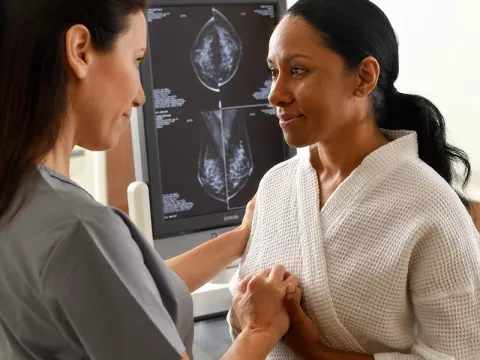Nurse holding hands with a patient getting a scan