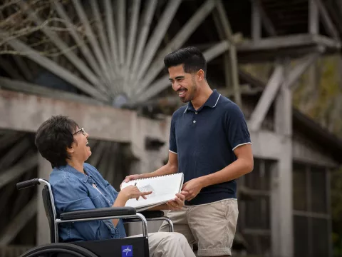 Woman in a wheelchair with her caregiver