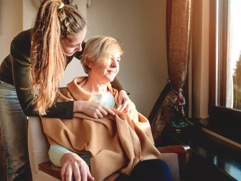 Younger woman taking care of female hospice patient