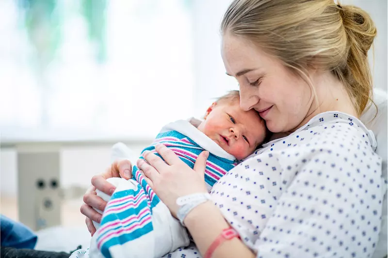 A mom holding her newborn.