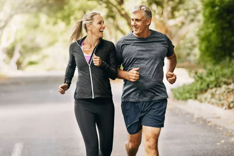 A man and a woman running on an incline
