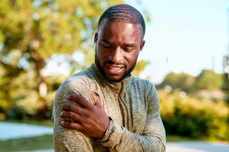 African American Man rubbing sore shoulder