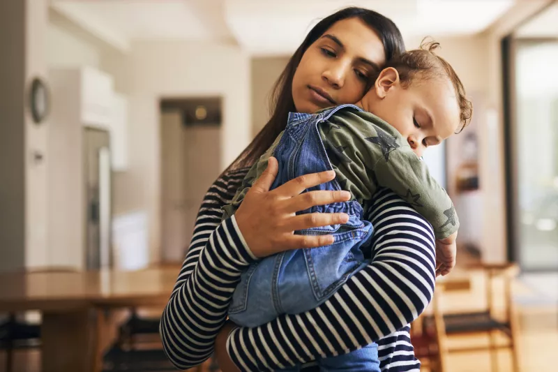 Mother holding young sleeping child