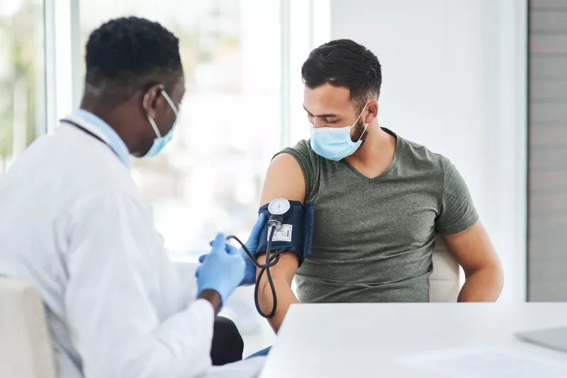 A Doctor Takes a Patient's Blood Pressure with a Blood Pressure Cuff