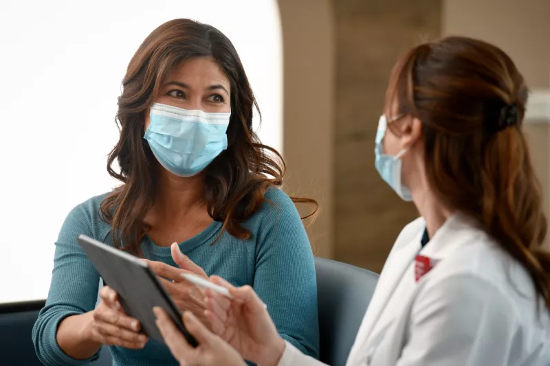 A Woman Consults With Her Doctor with a Tablet.