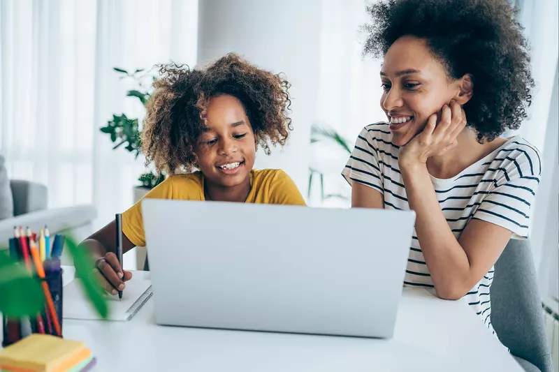 A Mother and Daughter Surf the Internet on a Laptop in Their Home.