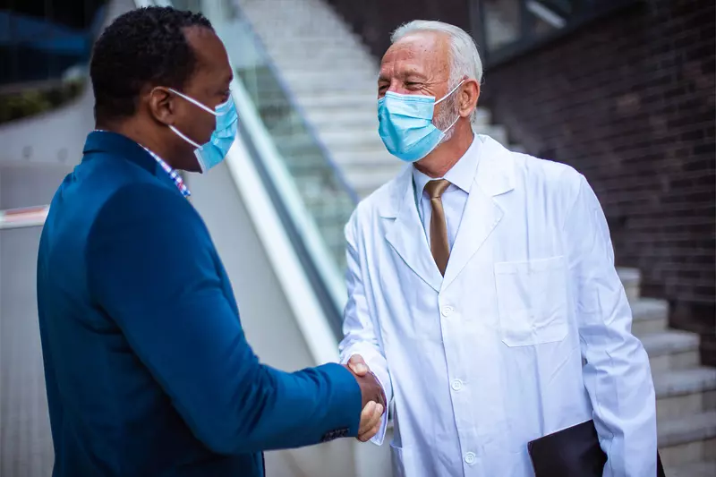 A gentleman shaking a doctor's hand