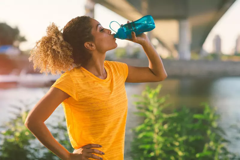 Woman on a run drinking water 