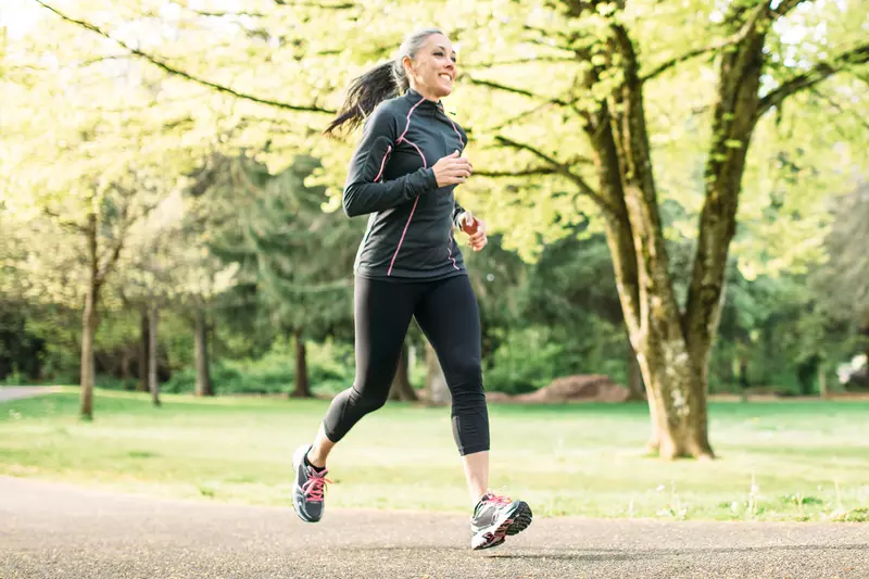 A Woman Runs Through a Wooded Park