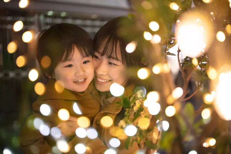 A Mother and Son Enjoy Christmas Lights Outside in the Winter Weather