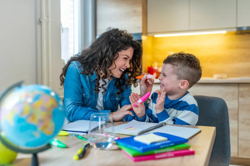 Mother and Son HAve Fun Coloring and Learning at the Kitchen Table