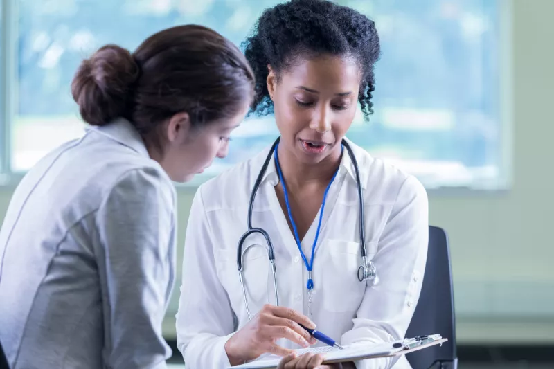 A Physician Goes Over A Chart With Her Patient
