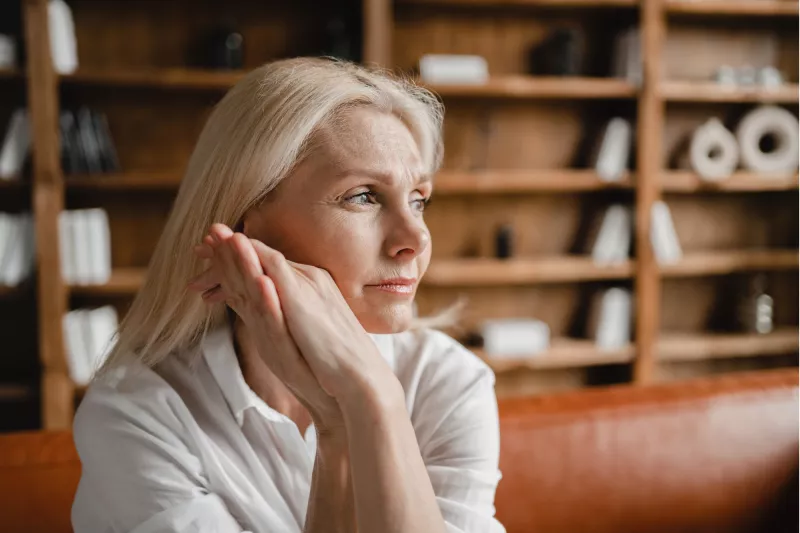 A Woman Thinks Deeply with Her Hand Pressed Against Her Face