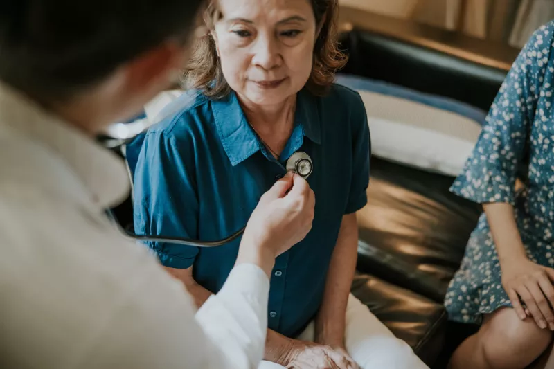 A Doctor Listens to a Patient's Heart with a Stethoscope