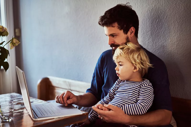 A Father and Son Sit and Surf the Internet From Home.