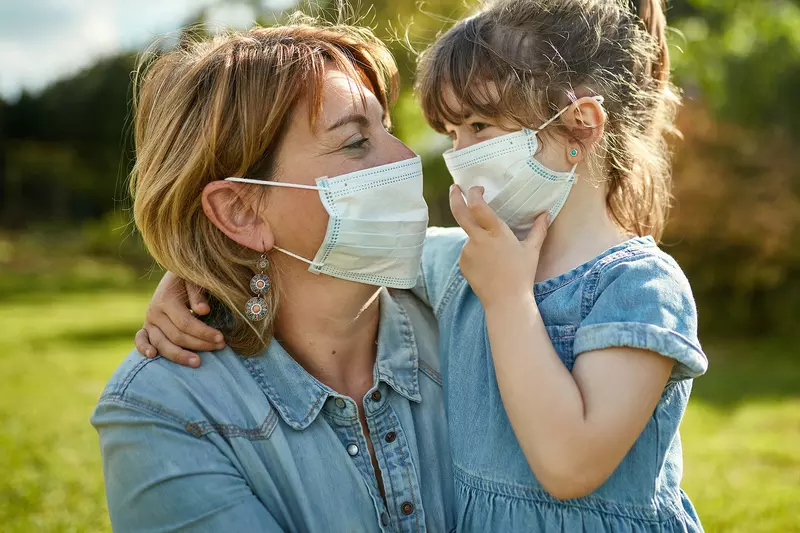A mom and daughter wearing face masks.