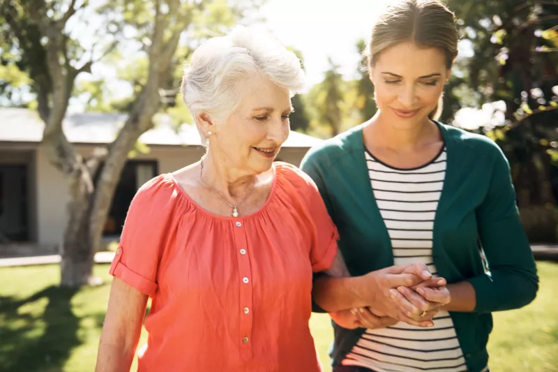 A mother and daughter, walking outside, offer emotional support to each other.