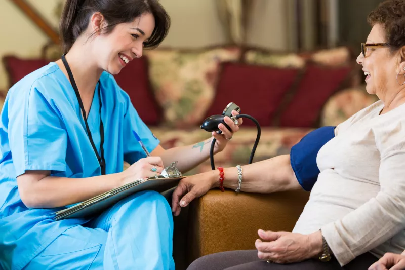 Woman having blood pressure screened