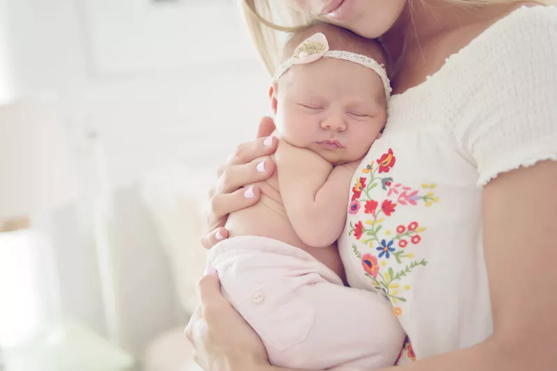Mother holding baby to her chest.
