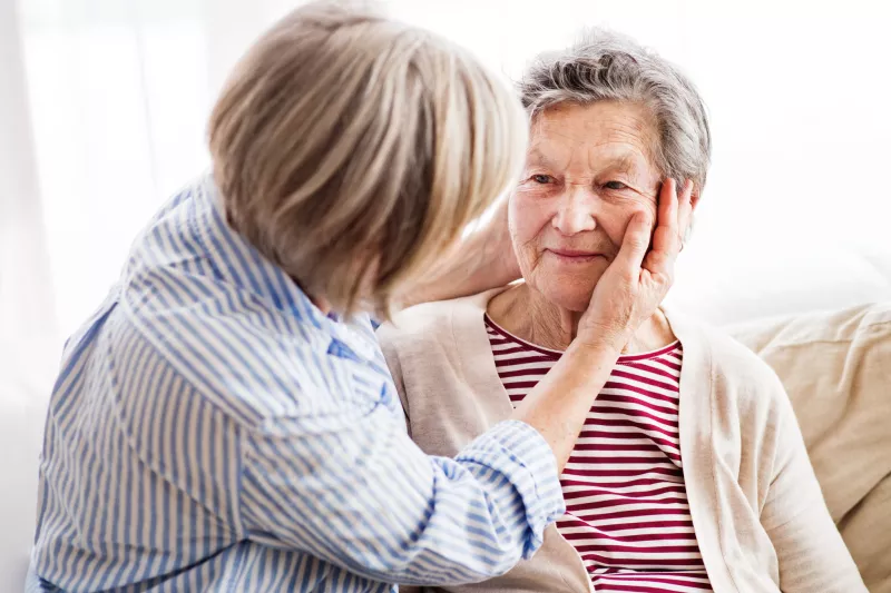 A daughter checks her mother for signs of a stroke.