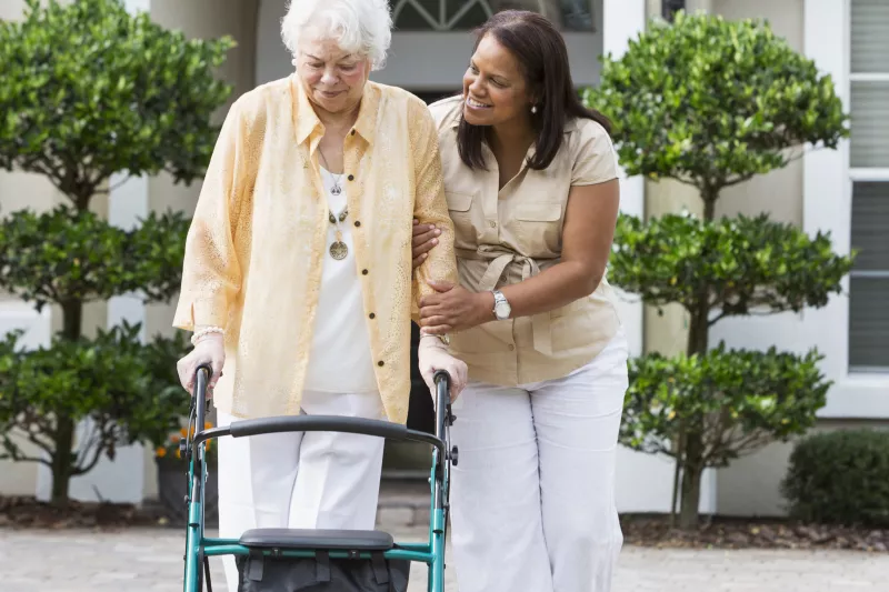 Woman in her driveway using a walker