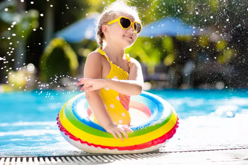A little girl enjoys a refreshing dip in the pool.