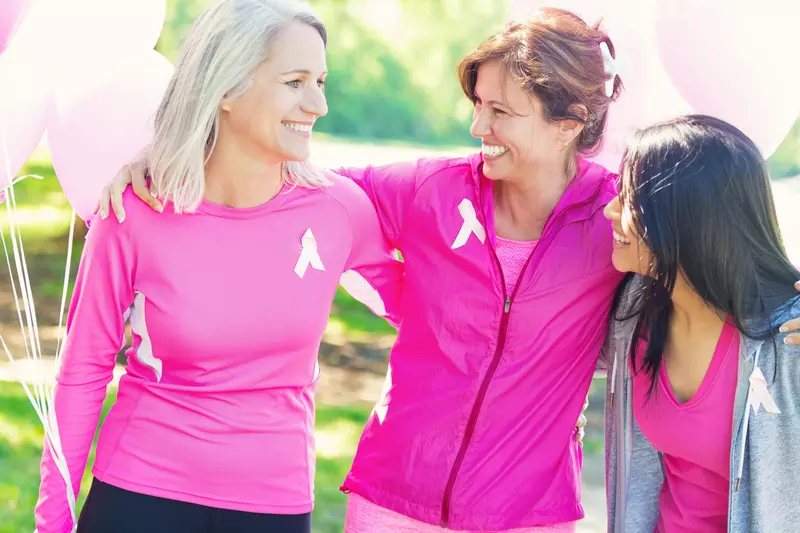 Three women wearing pink and celebrating breast health