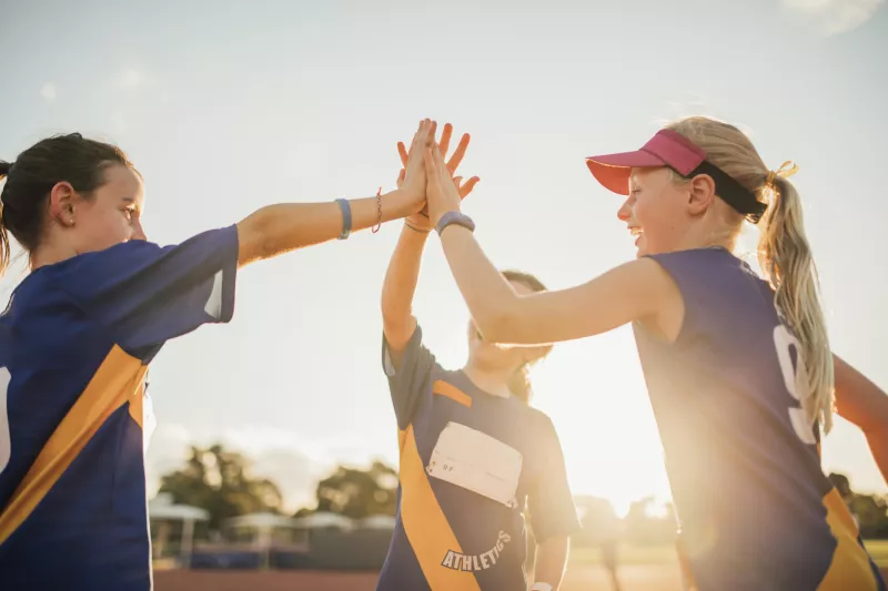 Young athletes high five after a good practice.