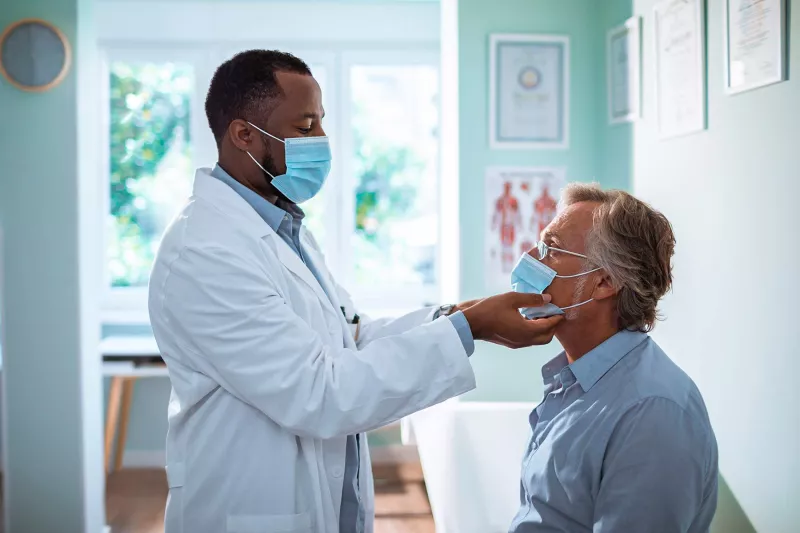 Man seeing doctor wearing PPE