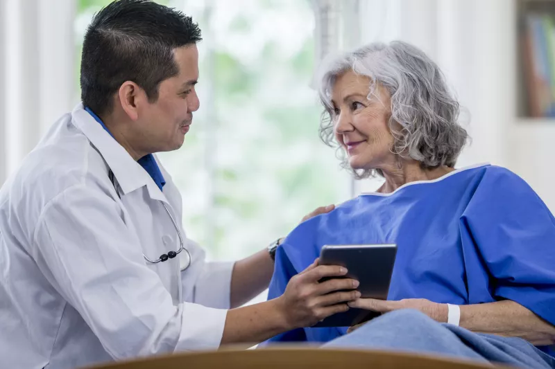 A male doctor and a senior woman patient, consulting.