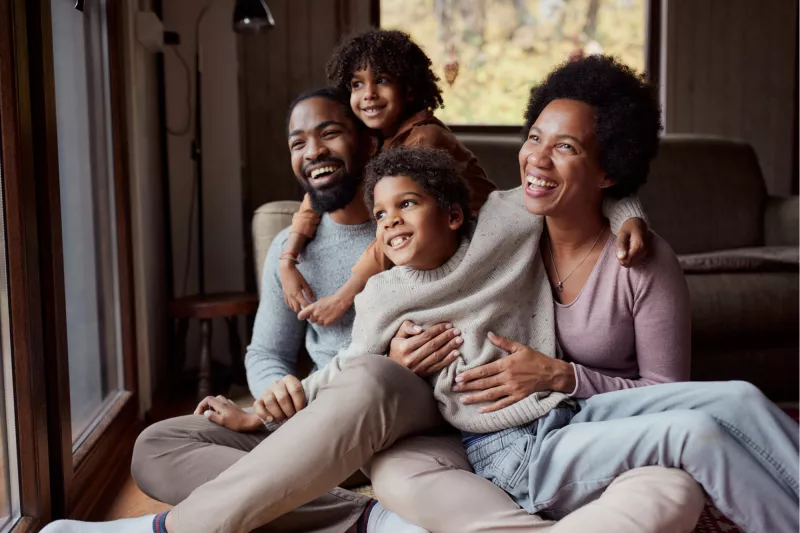 A happy African-American family looking out the window