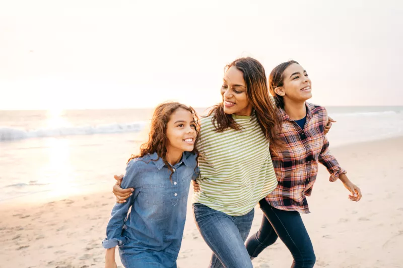 Mother and Daughters Walking on the Beach