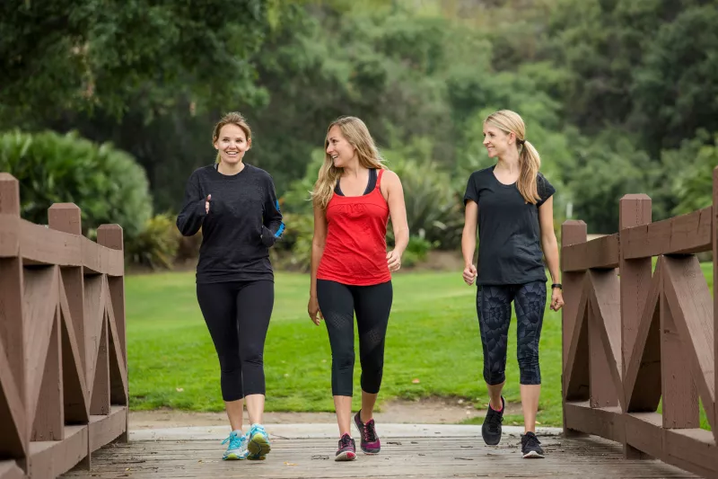 Three women in their 30s enjoy their morning walk.
