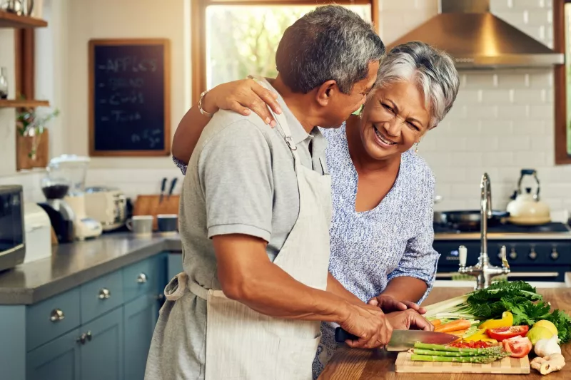 A couple prepares a meal full of vegetables.