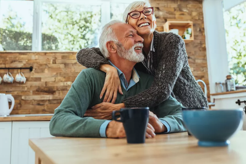A couple hugging in the kitchen.