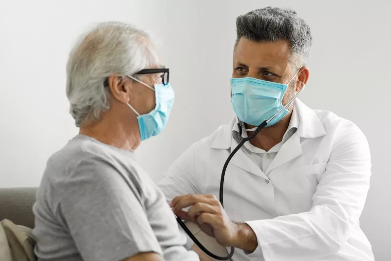 A doctor listening a patient's heart.