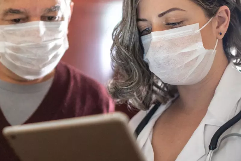 A doctor showing her patient something on her business tablet
