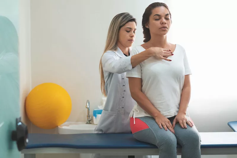 A doctor examines a patient's spine.