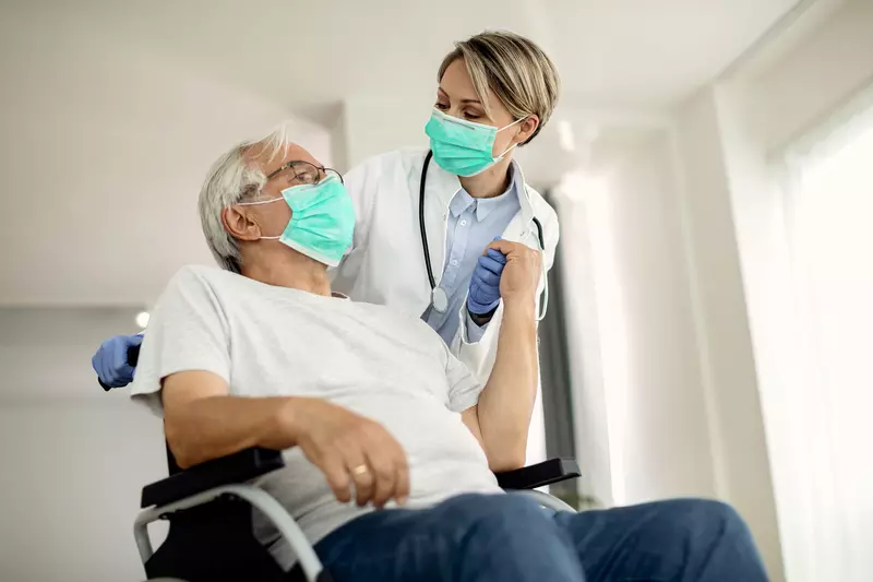 A senior man being assisted by a nurse