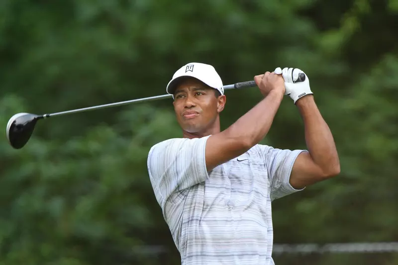 Golfer, Tiger Woods, watches his ball fly after swinging his golf club