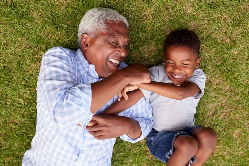 A grandfather playing with his young grandson.