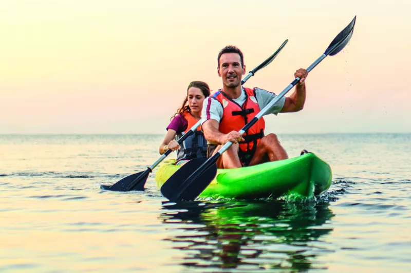 A couple kayaking on calm waters.