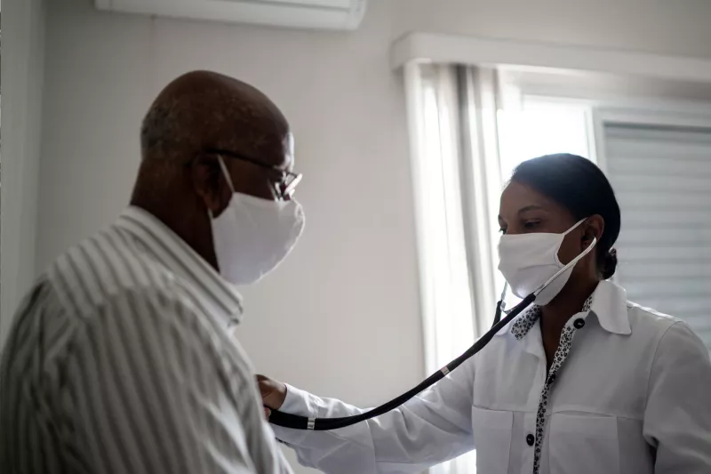 A doctor using a stethoscope on a patient