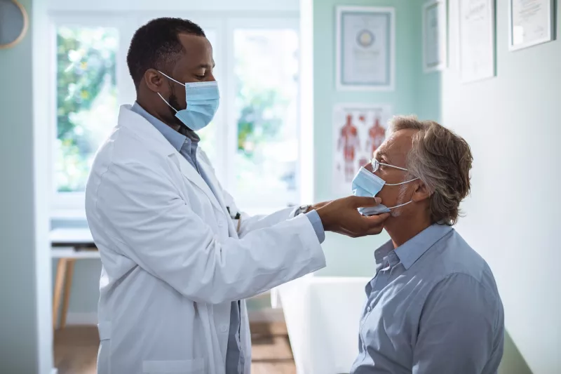 A male doctor examining a male patient.